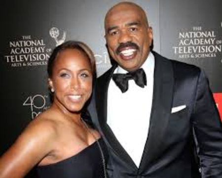 Steve Harvey in a black tux poses a picture with wife Marjorie Bridges-Wood at an award show.